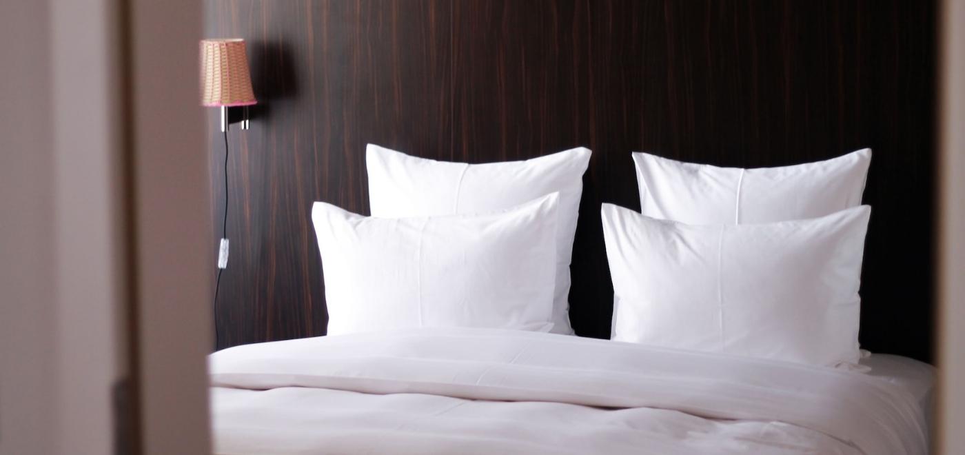 Hotelbett mit weißer Bettwäsche